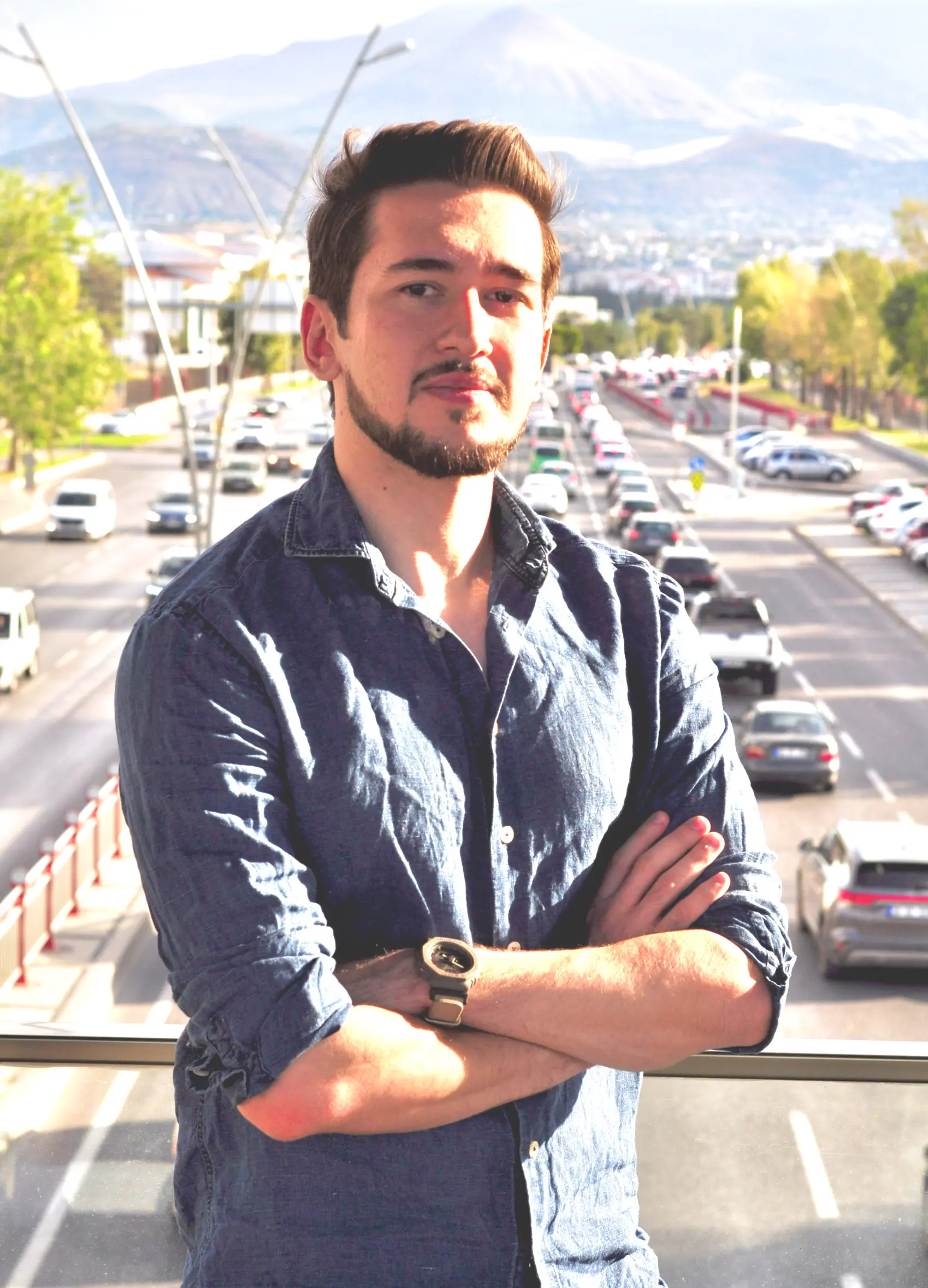 Mete on a pedestrian bridge over a highway in a sunny day. Car traffic, green trees and mountains on the background.